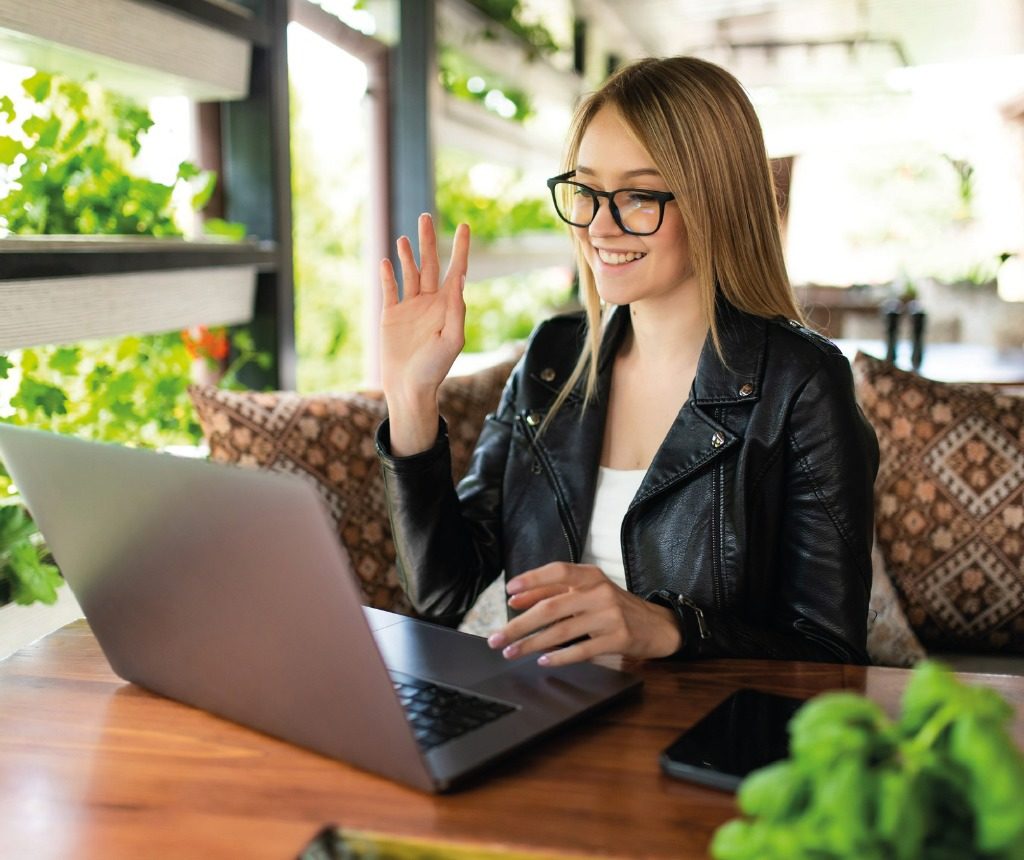 Chica con notebook reunion virtual saludando
