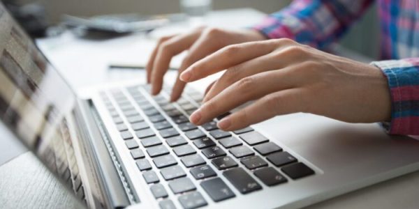 cropped-view-hands-typing-laptop